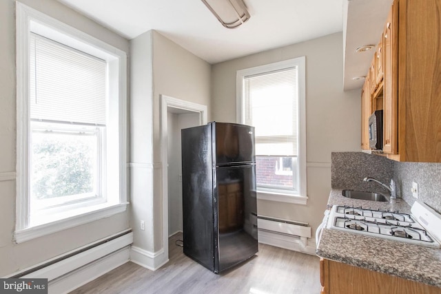 3547 N 21st St, Philadelphia, PA 19140 - kitchen with a baseboard heating unit, stainless steel microwave, a sink, freestanding refrigerator, and a baseboard radiator