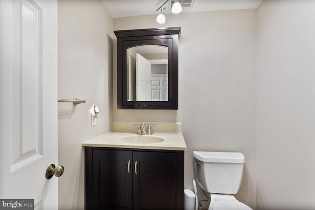 half bath featuring toilet and vanity
