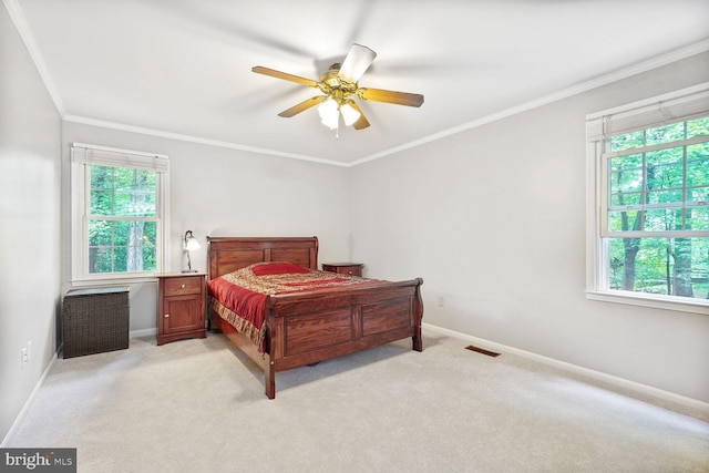 bedroom featuring baseboards, ornamental molding, light colored carpet, and ceiling fan
