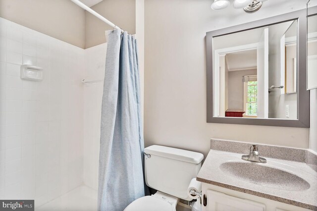 full bath featuring a shower with shower curtain, toilet, and vanity
