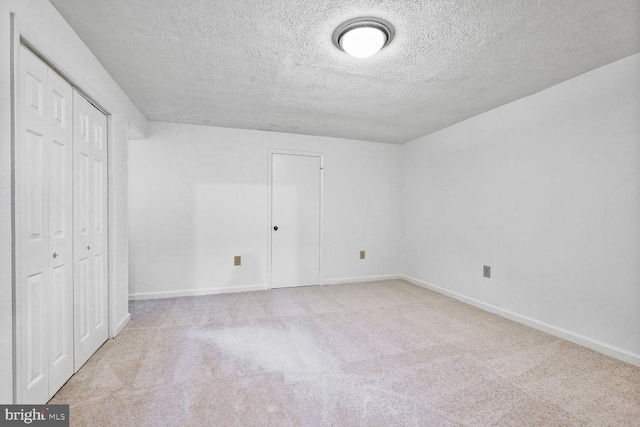 unfurnished bedroom featuring a textured ceiling, carpet, baseboards, and a closet