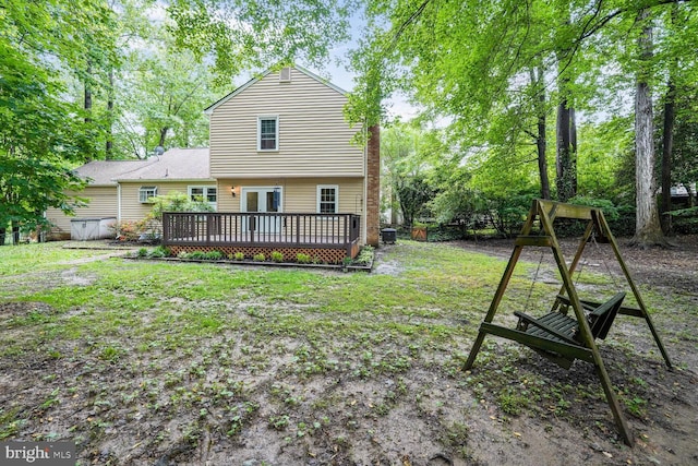 back of property featuring a wooden deck, a lawn, and french doors