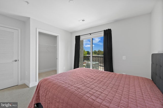 carpeted bedroom with a closet, a walk in closet, baseboards, access to exterior, and visible vents