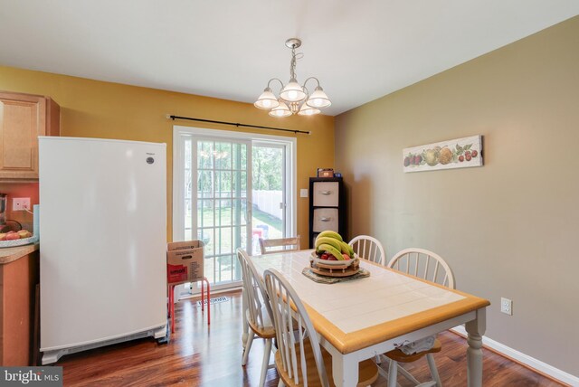 dining room with baseboards, a healthy amount of sunlight, a chandelier, and dark wood-style floors