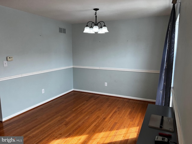 209 Preston Ln, Clayton, DE 19938 - spare room with an inviting chandelier, wood finished floors, visible vents, and baseboards