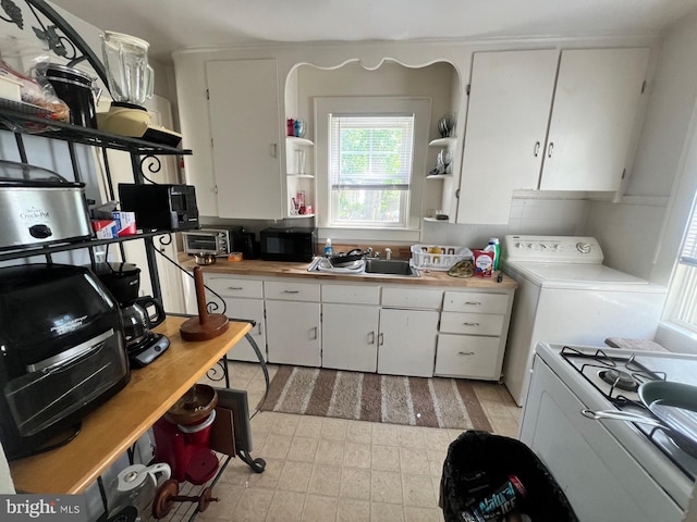 611 Truitt St, Salisbury, MD 21804 - kitchen with black microwave, washer / clothes dryer, open shelves, and white cabinets