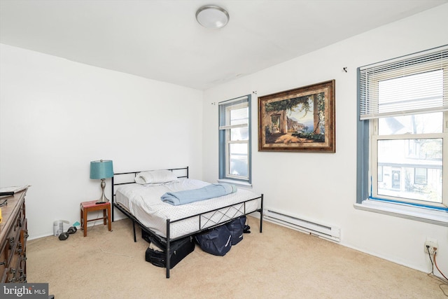 bedroom featuring a baseboard heating unit, carpet floors, and baseboards