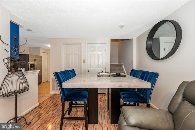 558 Hollyberry Way, Frederick, MD 21703 - dining space featuring baseboards, a textured ceiling, and light wood-style flooring
