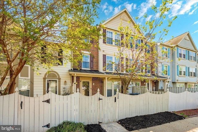 558 Hollyberry Way, Frederick, MD 21703 - townhome / multi-family property with brick siding, a gate, and a fenced front yard