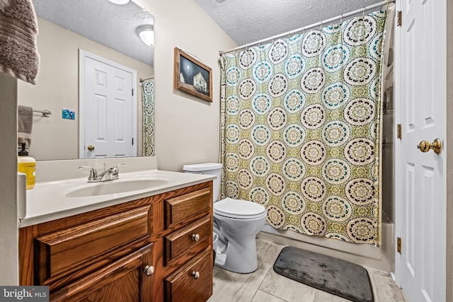 bathroom featuring vanity, shower / bathtub combination with curtain, toilet, and a textured ceiling