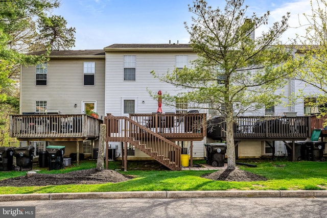 rear view of house featuring stairway, a yard, and a deck