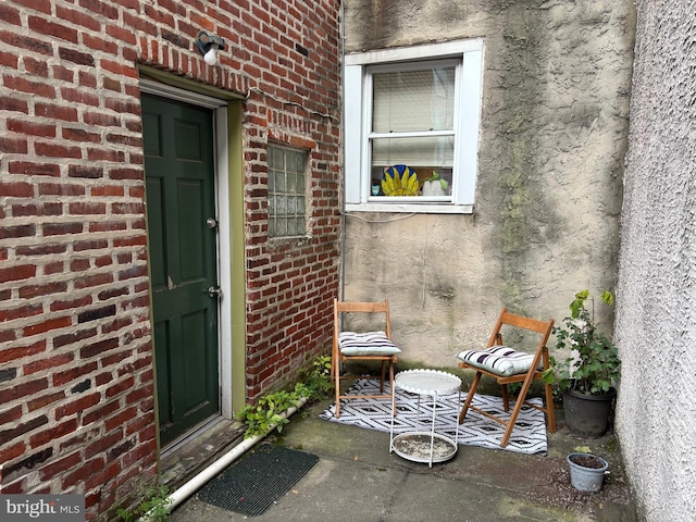 view of exterior entry featuring brick siding
