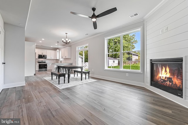 3519 Cedar Dr, Edgewater, MD 21037 - dining area with a glass covered fireplace, ornamental molding, ceiling fan with notable chandelier, and visible vents