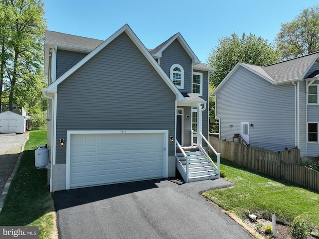 3519 Cedar Dr, Edgewater, MD 21037 - view of front facade featuring fence, a front yard, a shed, and aphalt driveway