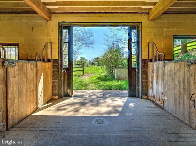 227 Jackson Rd, Cochranville, PA 19330 - doorway with healthy amount of natural light, beam ceiling, and wood walls