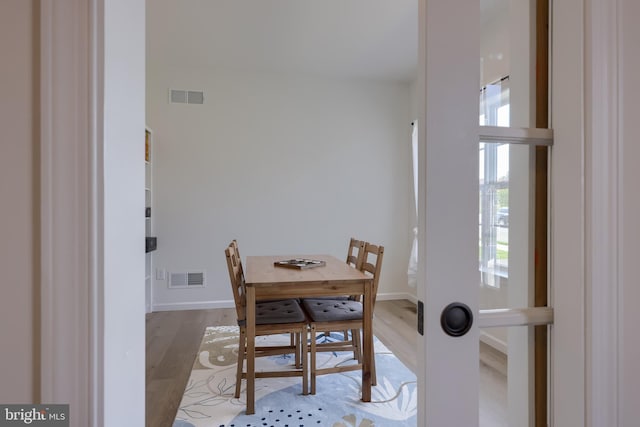 dining area featuring visible vents, a healthy amount of sunlight, and wood finished floors