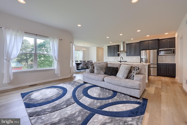 living room with recessed lighting, light wood-style flooring, and a wealth of natural light