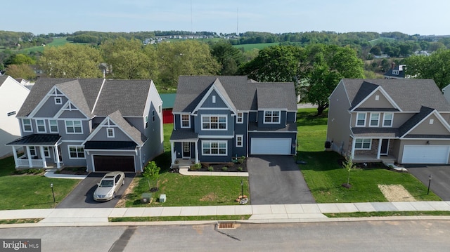 view of front of house with an attached garage, a front yard, and aphalt driveway