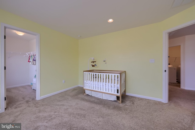carpeted bedroom featuring visible vents, baseboards, washer / clothes dryer, a walk in closet, and recessed lighting