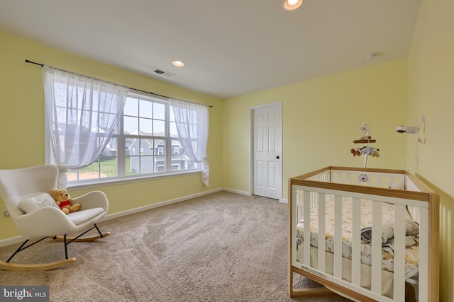 carpeted bedroom with recessed lighting, baseboards, a nursery area, and visible vents