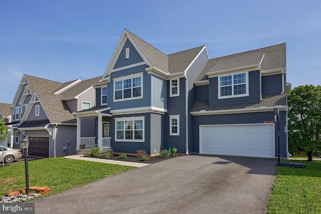 view of front of property featuring driveway, a shingled roof, a front yard, and a garage