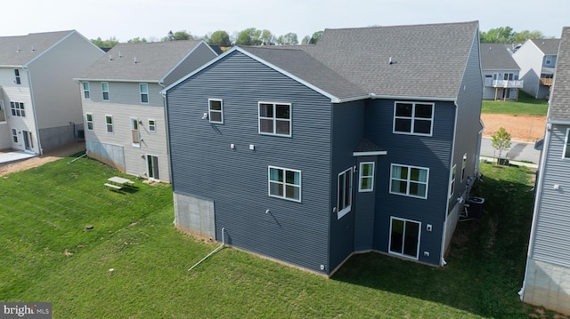 rear view of property with a yard and central AC