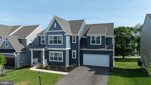 view of front facade with roof with shingles, a garage, a front yard, and aphalt driveway