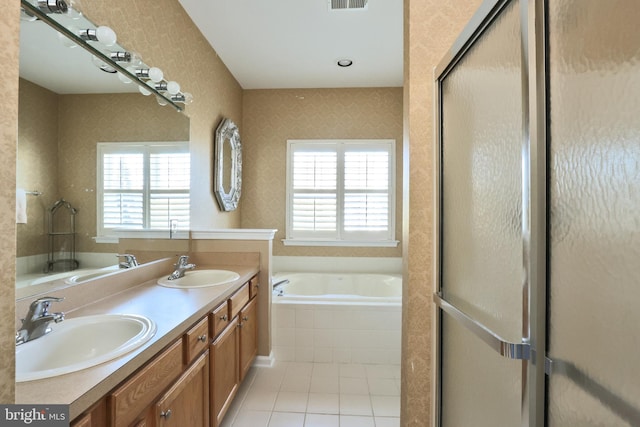 bathroom featuring visible vents, a garden tub, tile patterned floors, and a sink