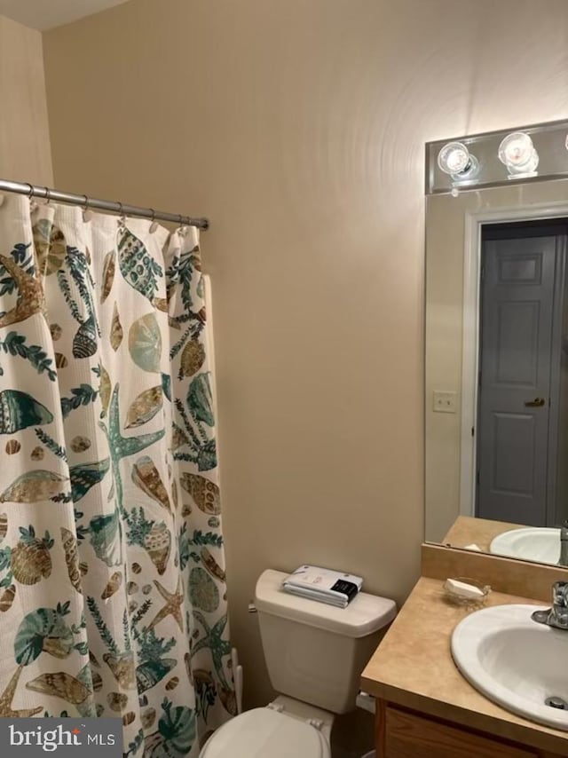 full bath with curtained shower, toilet, and vanity