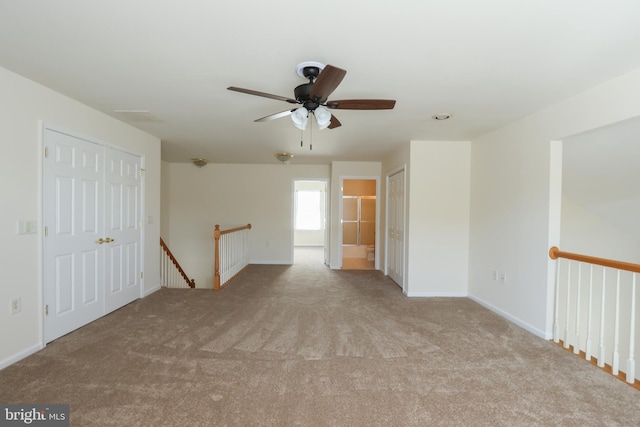 unfurnished room featuring carpet, baseboards, and ceiling fan