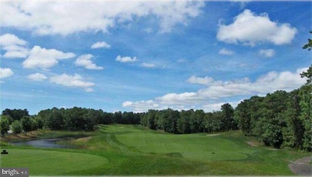 view of home's community with view of golf course and a view of trees