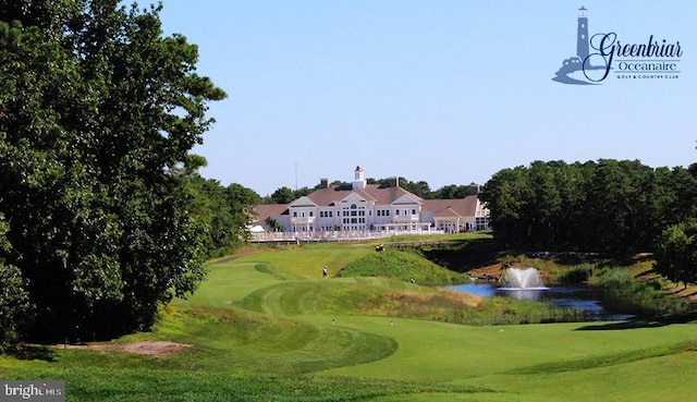 view of home's community with a lawn, view of golf course, and a water view