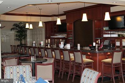 bar featuring decorative light fixtures and a community bar