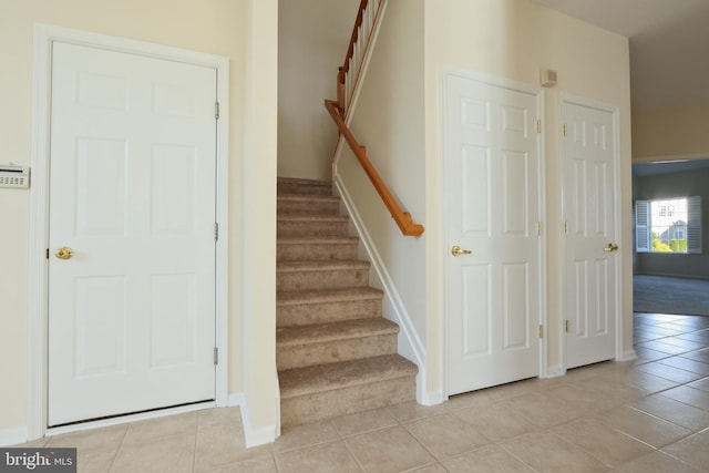 staircase featuring baseboards and tile patterned flooring