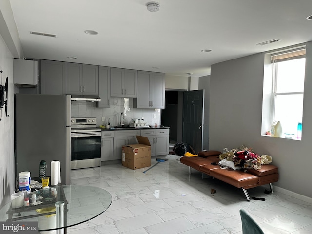 2108 Ridge Ave, Philadelphia, PA 19121 - kitchen with marble finish floor, under cabinet range hood, stainless steel appliances, visible vents, and gray cabinetry
