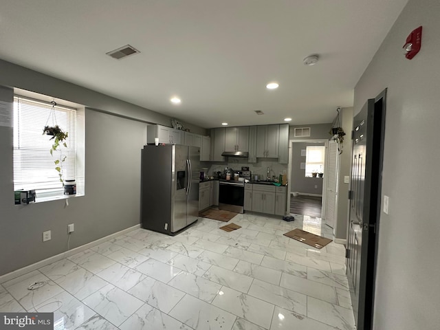 2108 Ridge Ave, Philadelphia, PA 19121 - kitchen featuring stainless steel appliances, gray cabinetry, under cabinet range hood, and baseboards