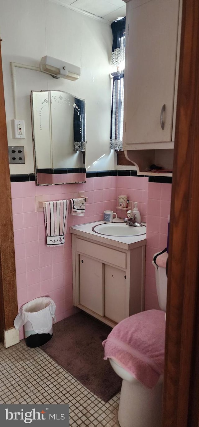 bathroom featuring vanity, a wainscoted wall, and tile walls