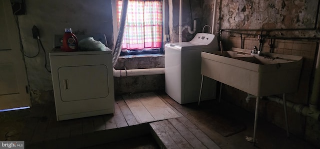 laundry room with hardwood / wood-style floors, a sink, and washer and clothes dryer