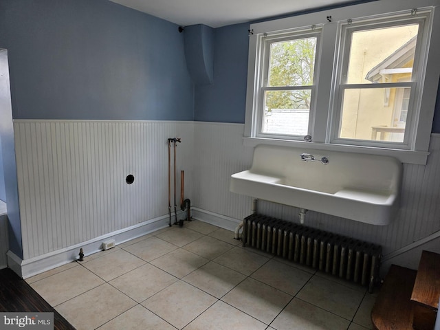 bathroom featuring radiator heating unit, baseboards, wainscoting, and tile patterned floors