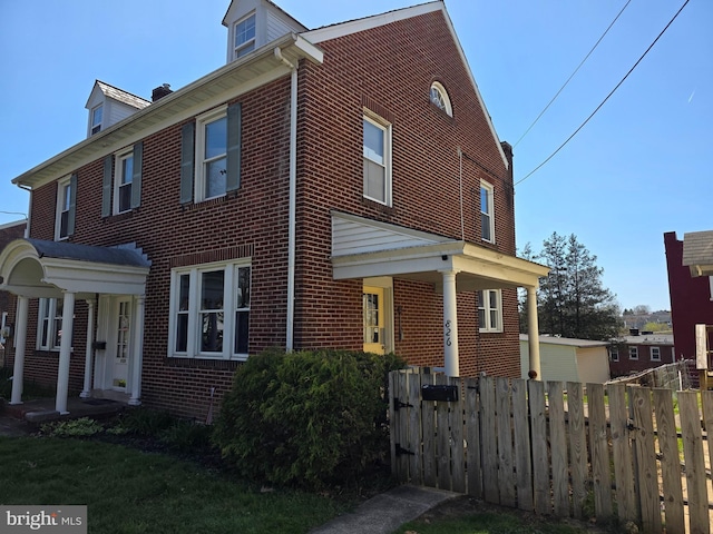 view of front of house with fence and brick siding