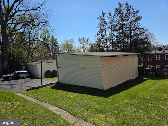 view of outbuilding featuring fence