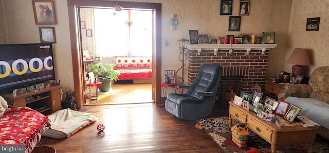 living area with wallpapered walls, wood finished floors, and a fireplace