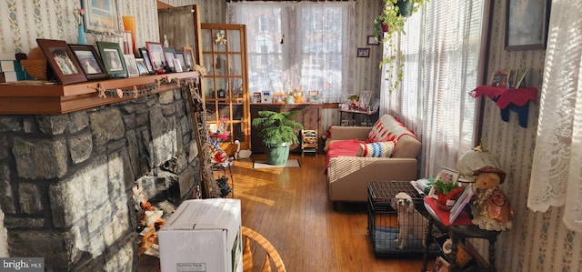 sitting room featuring wood-type flooring, wallpapered walls, and plenty of natural light