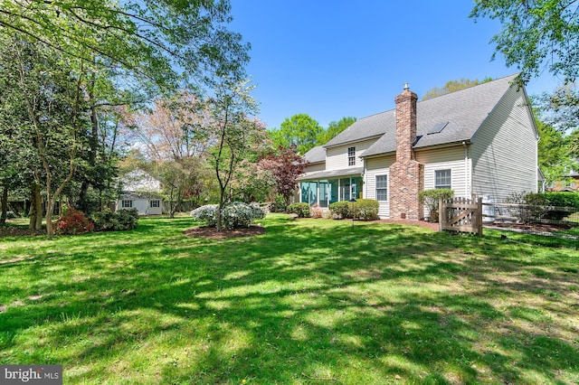 view of yard featuring fence and a sunroom