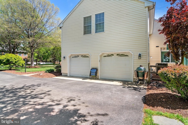 view of property exterior with driveway and a garage