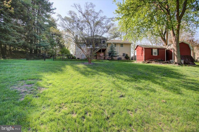 view of yard featuring fence, an outdoor structure, and a shed
