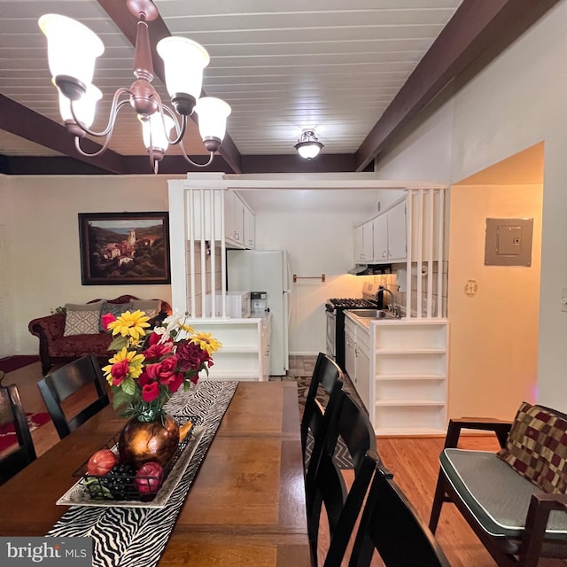 dining space with a chandelier, light wood-style floors, and electric panel