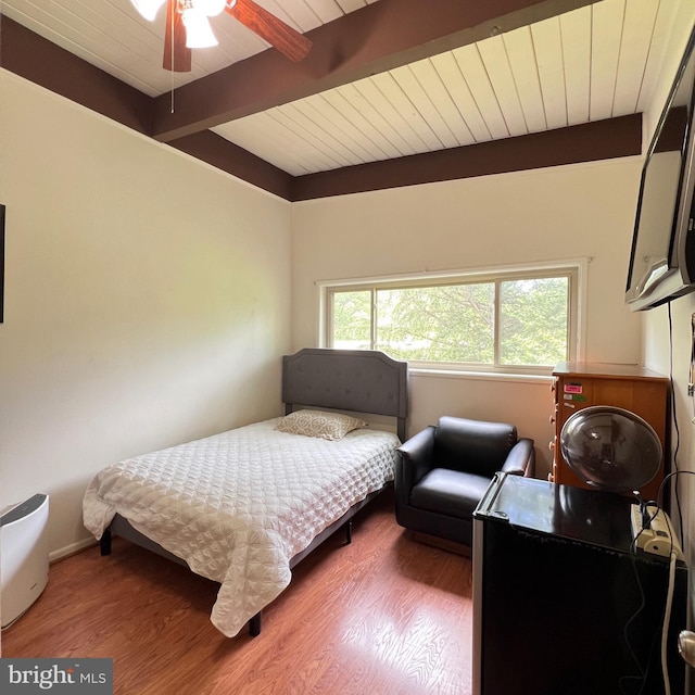 bedroom with beamed ceiling, wood finished floors, and wood ceiling