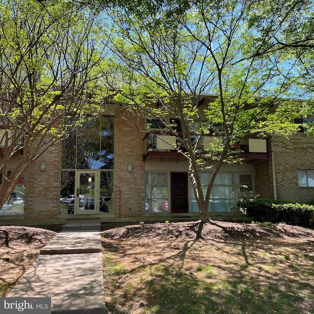 view of front of house with a balcony and brick siding