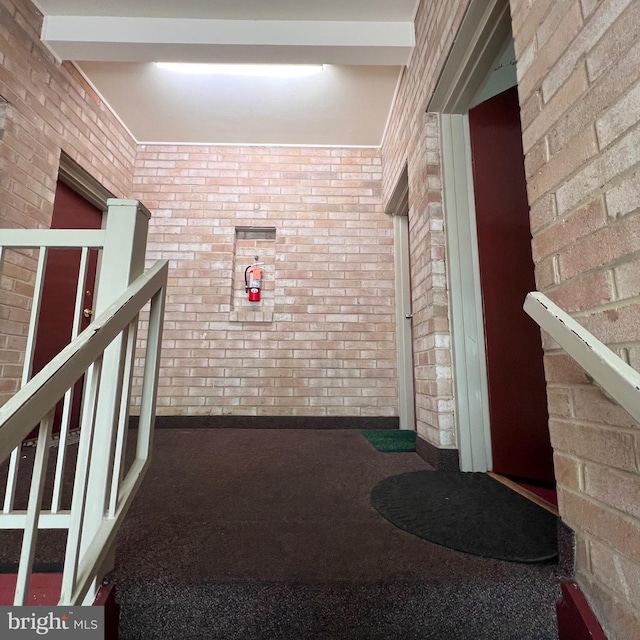 corridor featuring brick wall